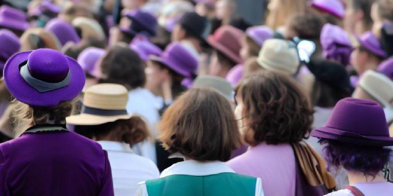 A crowd of women wearing Suffragette's colours