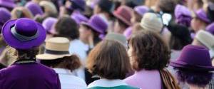 A crowd of women wearing Suffragette's colours